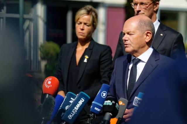 What are the risks of Scholz’s position regarding German aid to Ukraine?