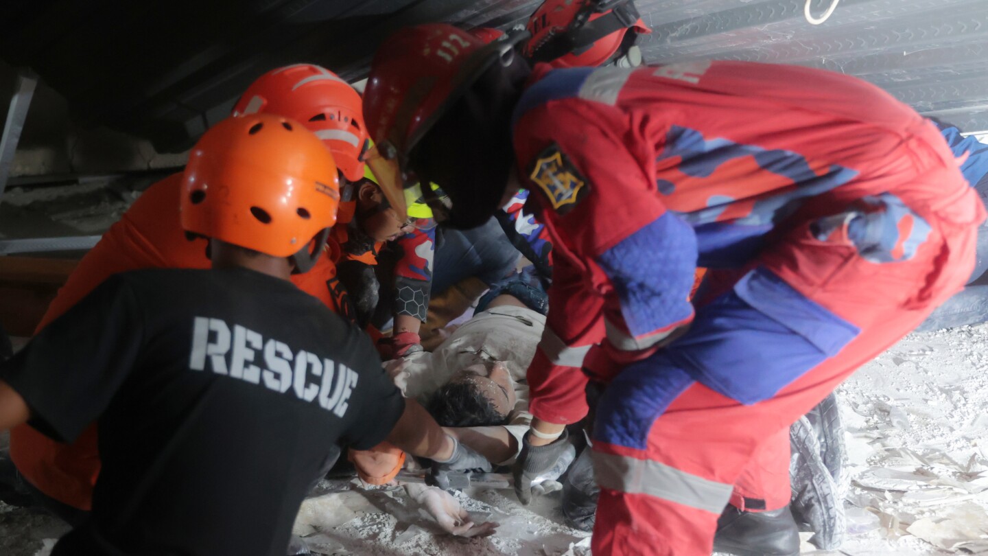 Rescuers run oxygen to survivors in Indonesia school building collapse that buried dozens